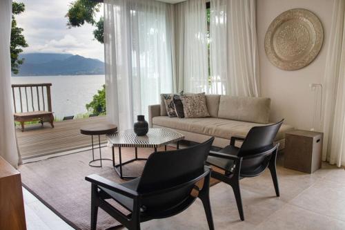 a living room with a couch and a table and chairs at Wyndham Ilhabela Casa Di Sirena in Ilhabela