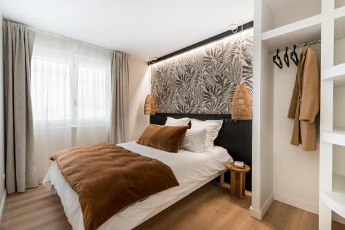 a bedroom with a bed with a brown blanket at La consulte - exceptional apartment in Saint-Étienne