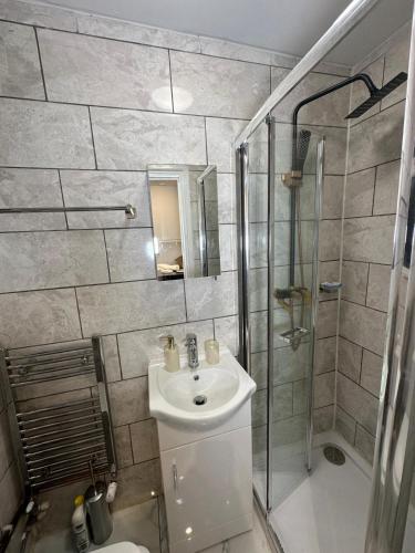 a bathroom with a sink and a shower at Two Bedrooms Bungalow Garden Lodge in Aveley