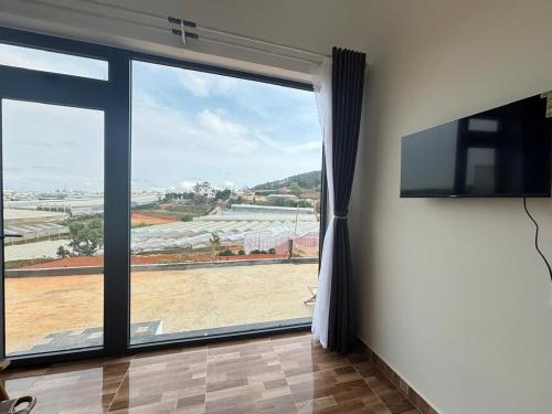 un salon avec une grande fenêtre avec vue dans l'établissement Villa Healing Home Hồ Bơi Nước Nóng, à Trai Mat
