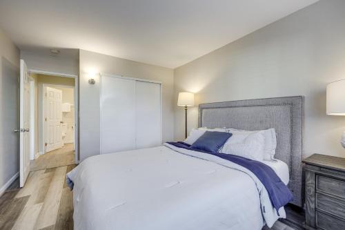 a bedroom with a large white bed with blue pillows at 2 Mi to Beaches Condo with Patio in Port Hueneme! in Port Hueneme