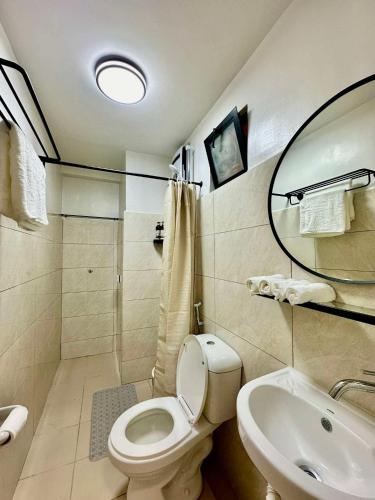 a bathroom with a toilet and a sink at Royal Oceancrest Panglao I in Dauis