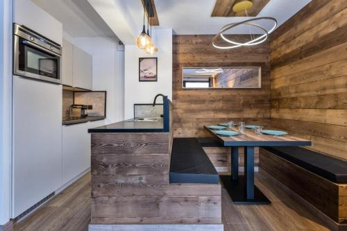 une cuisine avec des murs en bois et un comptoir avec une table dans l'établissement Résidence Le Balcon Des Airelles - Appartement calme au cœur des Orres 1800 MAE-9434, aux Orres