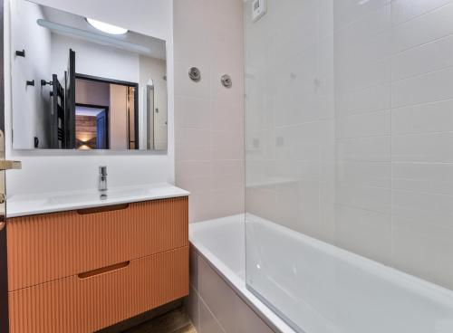 une salle de bain avec un lavabo, une baignoire et un miroir dans l'établissement Résidence Le Balcon Des Airelles - Appartement calme au cœur des Orres 1800 MAE-9434, aux Orres