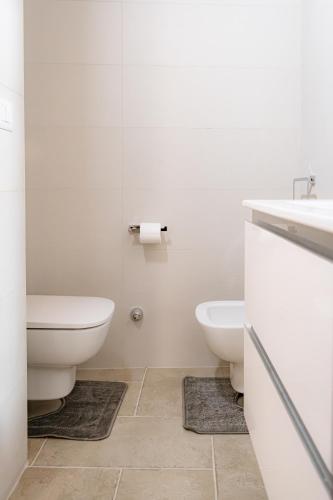 a white bathroom with two toilets and a sink at Vetritte Luxury in Bitritto