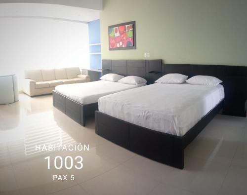 a bedroom with two beds and a couch at Playa Almendro Resort - Tonsupa in Tonsupa