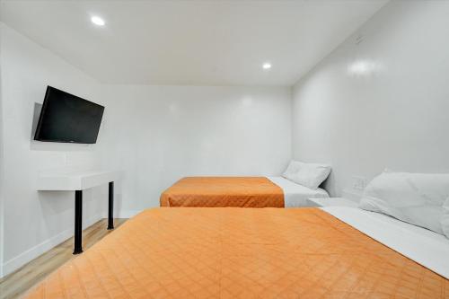 a bedroom with two beds and a desk and a television at Casablanca Inn in Bell