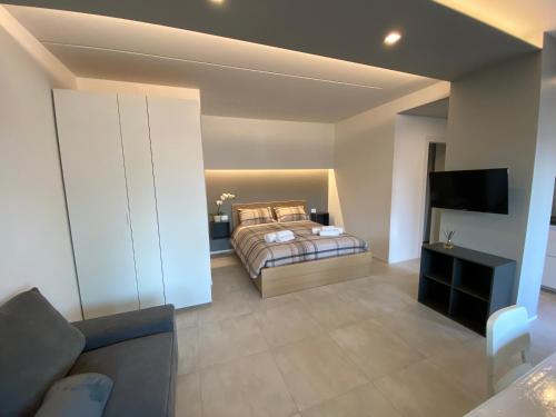 a bedroom with a bed and a flat screen tv at NEW Residenza le Essenze - i 7 Laghi in Erba
