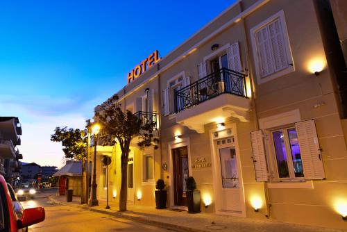 a building with a sign on it on a street at Hotel Kyani Akti in Xylokastron