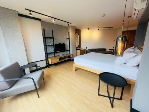 a bedroom with a bed and a chair and a tv at Hotel Casa Victoria in Medellín