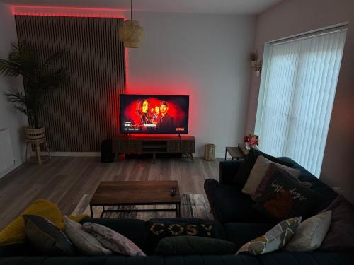a living room with a couch and a flat screen tv at Modern Flat in Glasgow City FREE Parking & Wifi in Glasgow