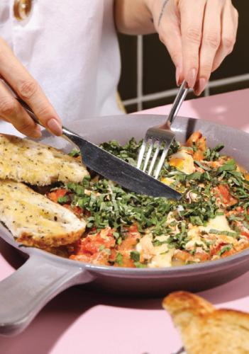 a person cutting a plate of food with a fork and knife at Celestino Boutique Hotel & Spa in Medellín