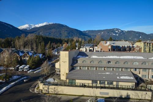an aerial view of a building with mountains in the background at Listel Whistler, a Coast Hotel in Whistler