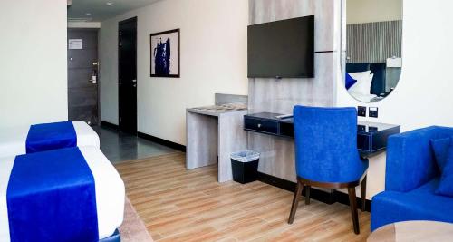 a room with a desk and two blue chairs at Best Western Hotel Rawalpindi Central in Rawalpindi