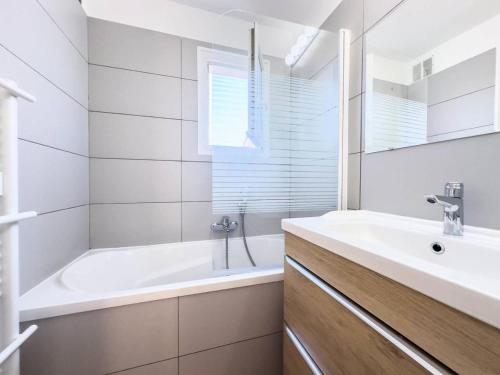 une salle de bain blanche avec une baignoire et un lavabo dans l'établissement Résidence Rivages - Superbe appartement 6 couchages face a la mer dans résidence avec piscine MAE-4991, à Six-Fours-les-Plages