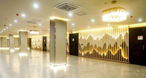 a lobby with gold and white walls and a chandelier at Best Western Hotel Rawalpindi Central in Rawalpindi