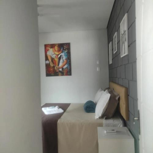 a room with a bed and a picture on the wall at Pousada Café Villa Monnaié in Chapada dos Guimarães
