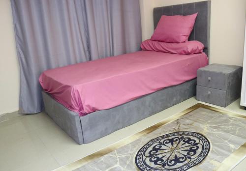a bed with pink sheets and a pink pillow at Hotel Rooms for rent Male only in Cairo