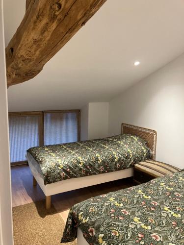 une chambre avec deux lits dans une pièce dans l'établissement Appartement Château de Corcelle, à Bourgvilain