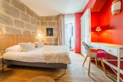 una camera da letto con pareti rosse, un letto e una sedia di Escale de Dali - 1 Chambre a Brive-la-Gaillarde