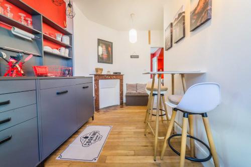 una cucina con un bancone e degli sgabelli di Escale de Dali - 1 Chambre a Brive-la-Gaillarde