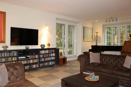a living room with a couch and a flat screen tv at Villa Abbamer in Grottaferrata