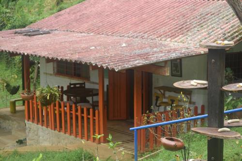 a house with a red roof and a porch at Finca la soñada in Papagalleros