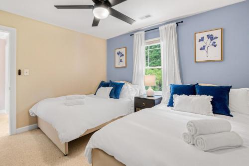 two beds in a bedroom with blue walls at 5BD Family Oasis, Pool, FirePit, Bball, Pong in High Point