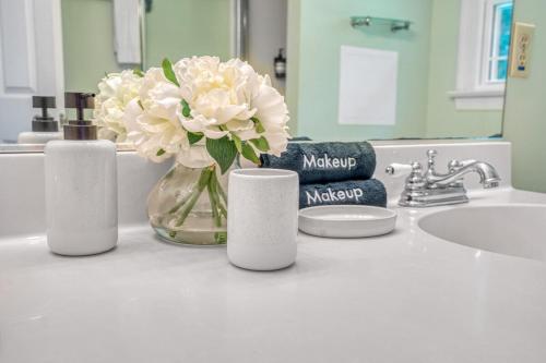 a bathroom counter with a vase of flowers and a sink at 5BD Family Oasis, Pool, FirePit, Bball, Pong in High Point