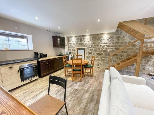 une cuisine et une salle à manger avec une table et des chaises dans l'établissement La Coquette du Bois - Wifi, Cosy, Familial, Calme, Bord de forêt, à Chenereilles