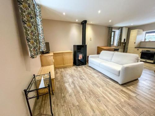 a living room with a white couch and a fireplace at La Coquette du Bois - Wifi, Cosy, Familial, Calme, Bord de forêt in Chenereilles