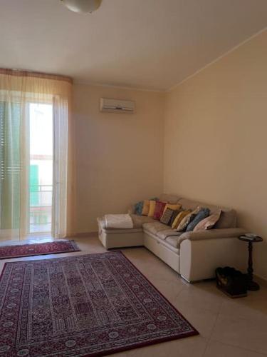a living room with a couch and a window at La casa del sole in Molfetta