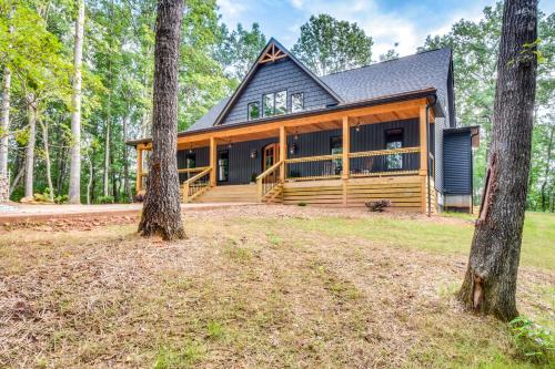 a large home with a large porch and trees at Luxurious Clarkesville Cabin with Decks and Fire Pit in Clarkesville