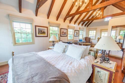 - une chambre avec un grand lit dans une pièce dotée de fenêtres dans l'établissement Romantic Carmel Cottage Ocean Country Views, à Carmel