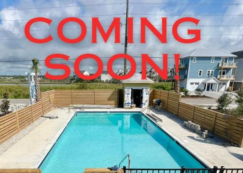 a swimming pool with a sign that reads coming soon at 2002 Queen Suite, 2nd Floor Surfside in Surf City