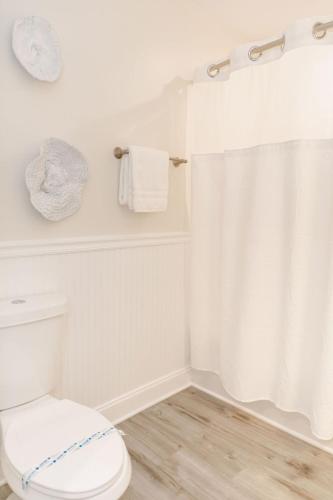 a white bathroom with a toilet and a shower at 2002 Queen Suite, 2nd Floor Surfside in Surf City