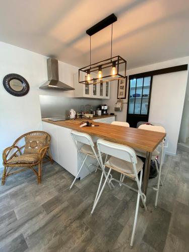 une cuisine et une salle à manger avec une table et des chaises en bois dans l'établissement Charming house in village centre with terrace, à Marseillan