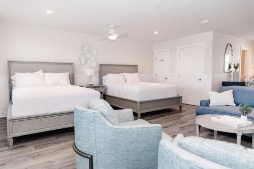 a bedroom with two beds and a couch and chairs at 2003 Queen Suite, 2nd Floor Cove in Surf City