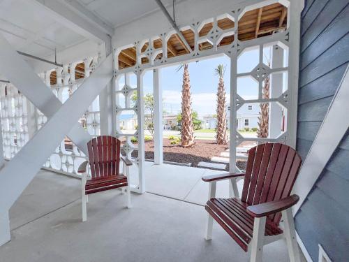 two chairs sitting on the porch of a house at 2004 Queen Suite, 2nd Floor Oasis in Surf City