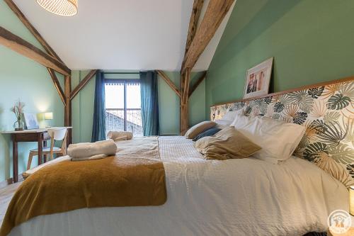 a bedroom with a large bed in a room at La Ferme des Hautins - Chambres -d'Hôtes in Rieucazé