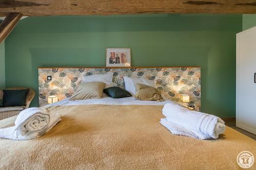 a large bed in a room with green walls at La Ferme des Hautins - Chambres -d'Hôtes in Rieucazé