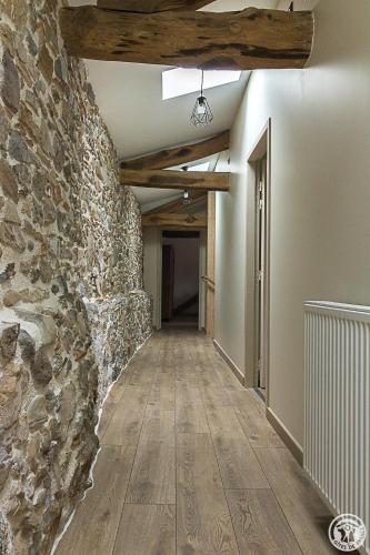 an empty hallway with a stone wall and wooden floors at La Ferme des Hautins - Chambres -d'Hôtes in Rieucazé