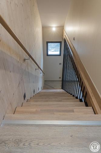 a staircase in a house with wooden floors and a window at La Ferme des Hautins - Chambres -d'Hôtes in Rieucazé