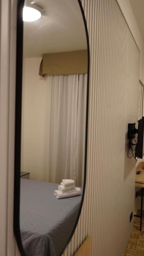 a mirror reflection of a bed in a room at Hotel Astoria in Fidenza
