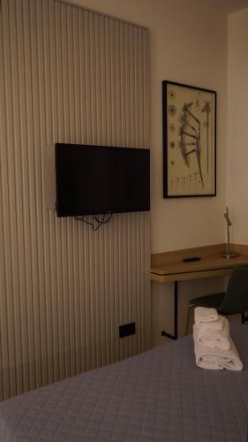 a hotel room with a bed and a flat screen tv at Hotel Astoria in Fidenza