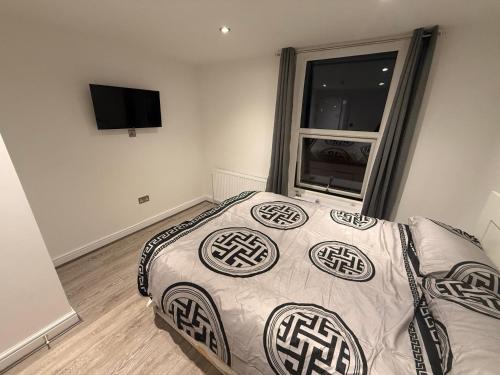 un dormitorio con una cama y una ventana en Luxe Guesthouse, en Stoke on Trent