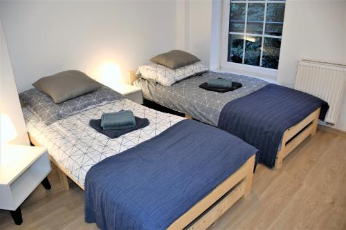 a room with three beds and a window at Apartament Starówka Piastowska in Olsztyn