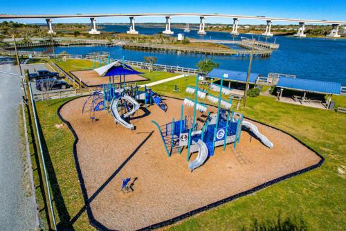 an empty playground in a park next to the water at 2008 King Suite, 2nd Floor Serenity in Surf City