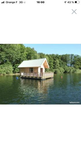 une maison sur un quai au milieu d'un lac dans l'établissement Chalets flottants lac saint Étienne Cantales, à Saint-Gérons