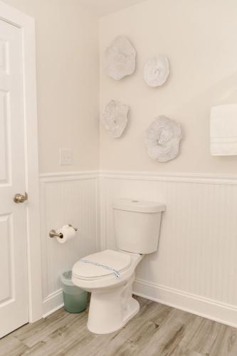 a bathroom with a toilet and towels on the wall at Adjacent 2nd Floor, 2004 Queen & 2005 Queen in Surf City